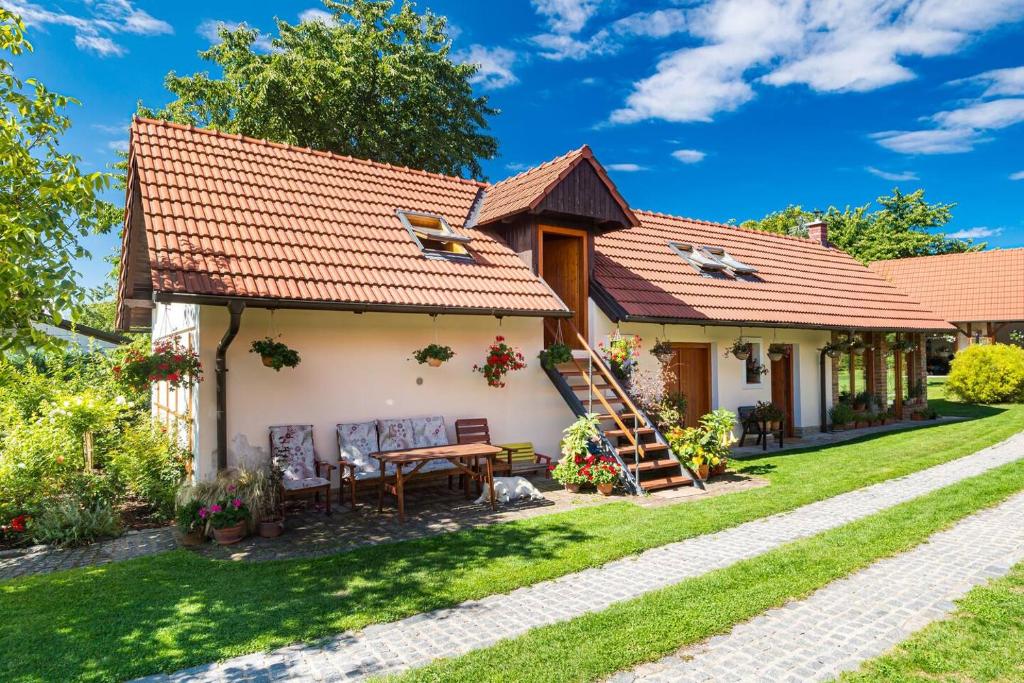 ein Cottage mit einem Tisch und Stühlen im Hof in der Unterkunft Tradiční český dům s ložnicemi v podkroví in Všejany