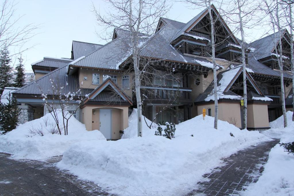 ein großes Haus mit Schnee seitlich in der Unterkunft Lagoons Condos by Whistler Retreats in Whistler