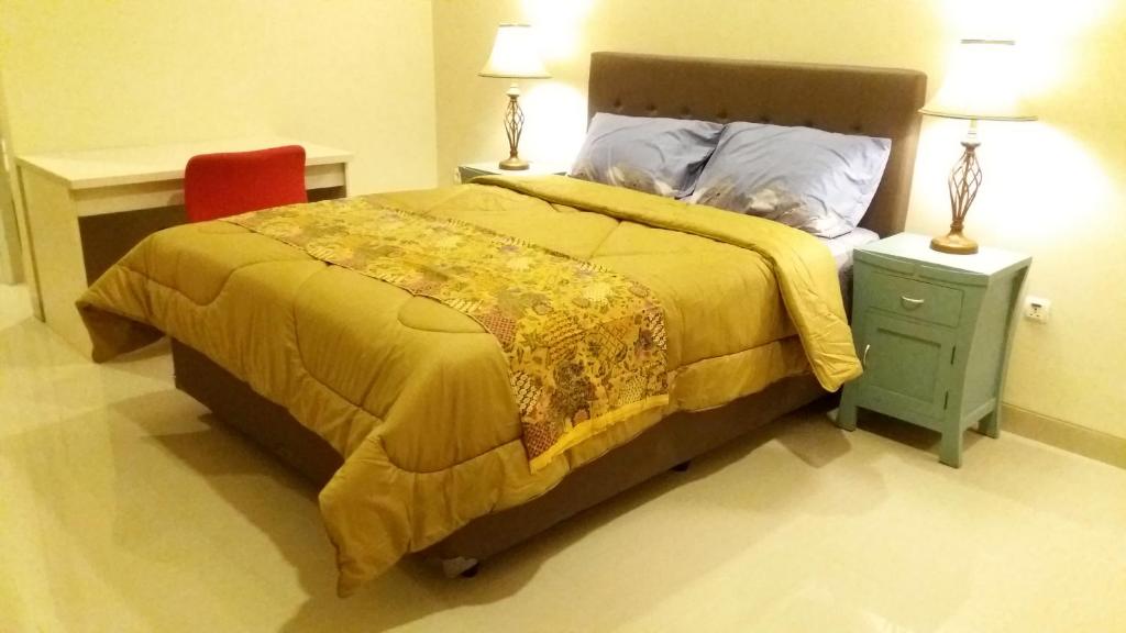 ein Schlafzimmer mit einem Bett und einem roten Stuhl in der Unterkunft Royal Adem Mejing in Ngabean