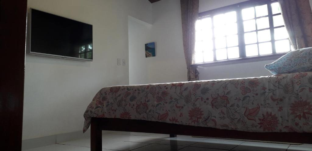 a living room with a couch and a flat screen tv at Apartamentos de Férias por Temporada Martim De Sá in Caraguatatuba