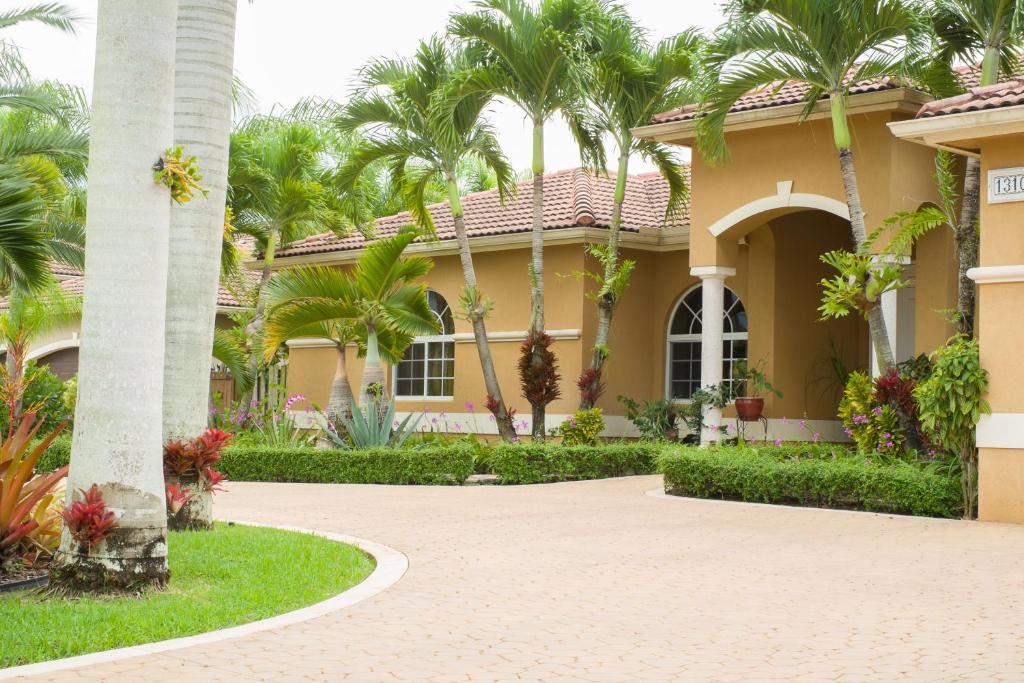 a house with palm trees and a driveway at Yuli's Home in Miami