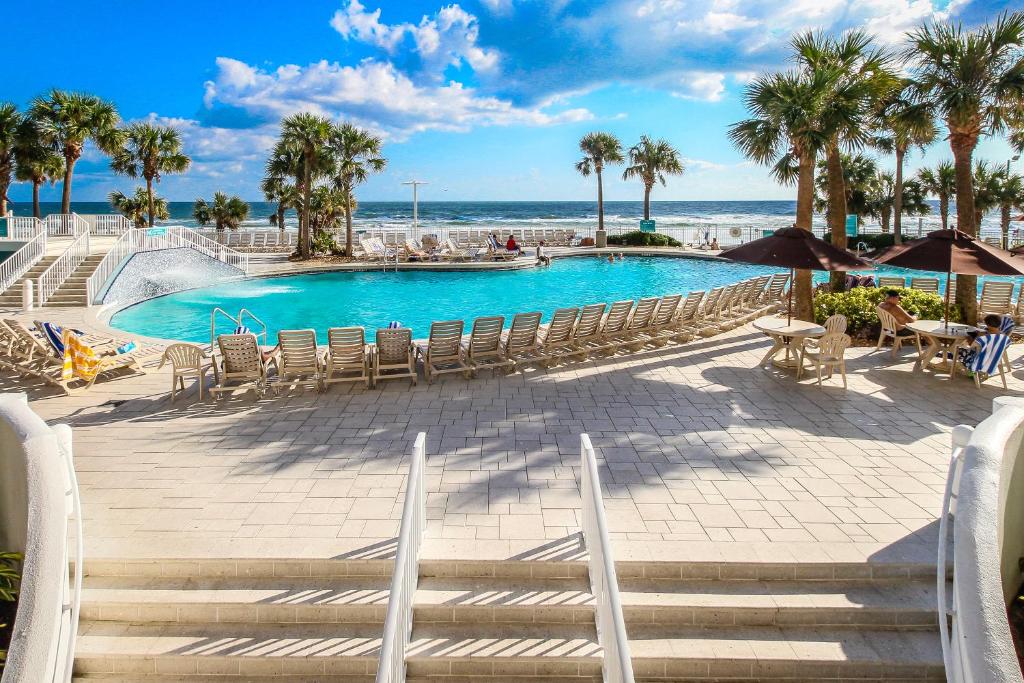 basen z krzesłami i ocean w tle w obiekcie Ocean Walk 2424B w mieście Daytona Beach