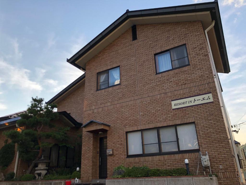 a brick building with a sign on it at Apartment at Toemu Nozawa in Nozawa Onsen