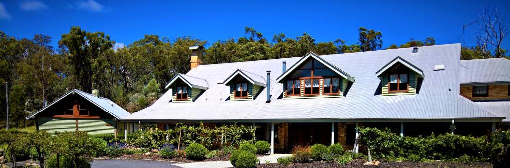 a house with a gambrel roof with windows at Girraween Country Inn in Ballandean