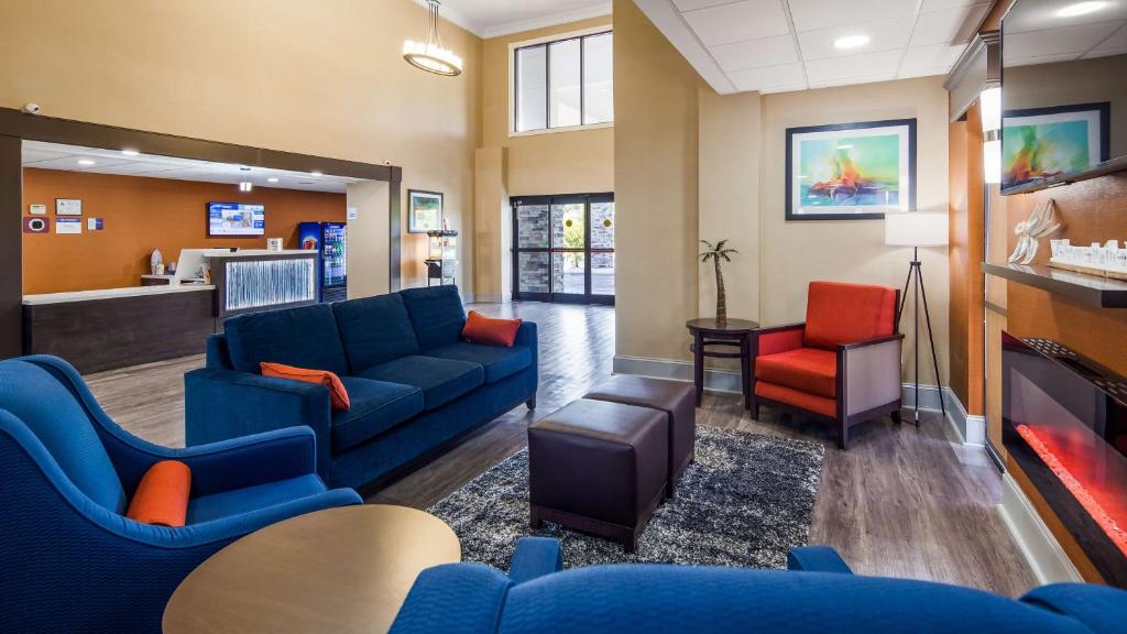 a waiting room with blue couches and red chairs at Best Western Shallotte / Ocean Isle Beach Hotel in Shallotte