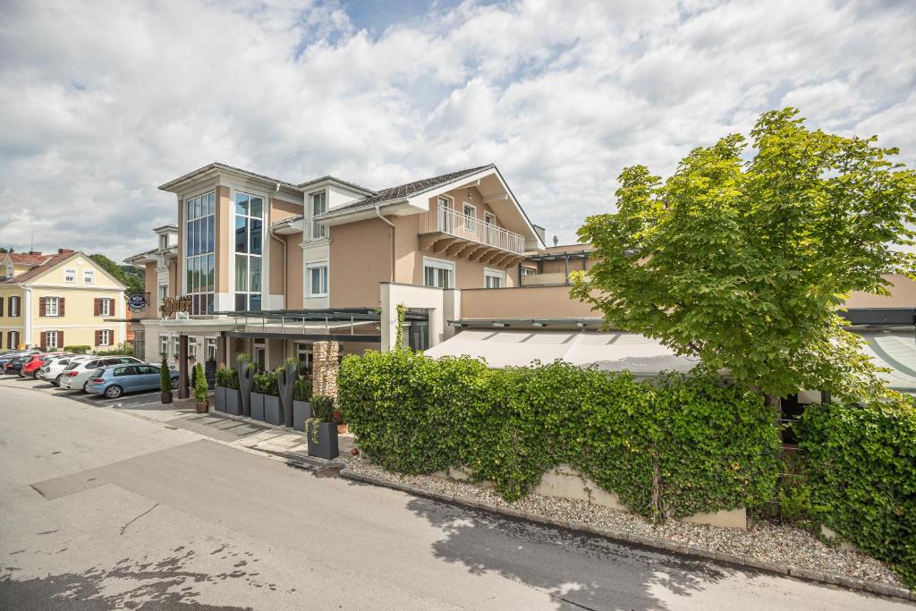 ein Gebäude auf einer Straße mit einem Baum in der Unterkunft Hotel-Restaurant Allmer in Weiz