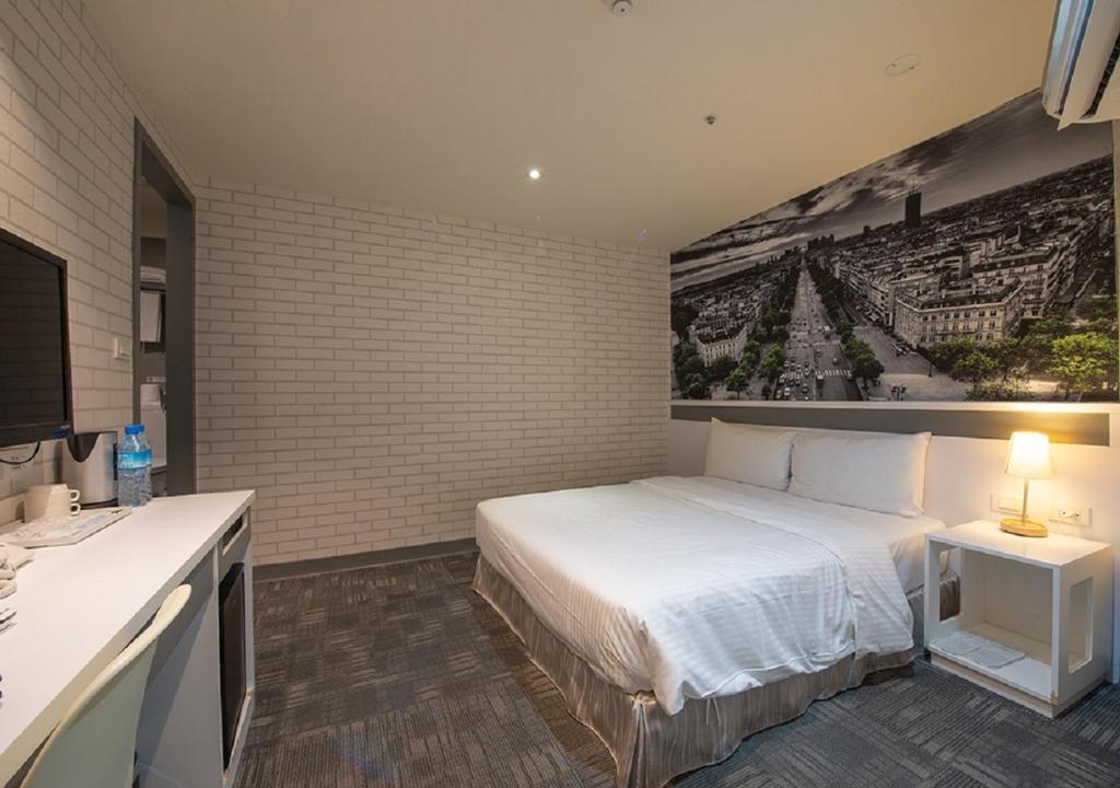 a bedroom with a bed and a painting on the wall at 9ine Hotel in Taipei