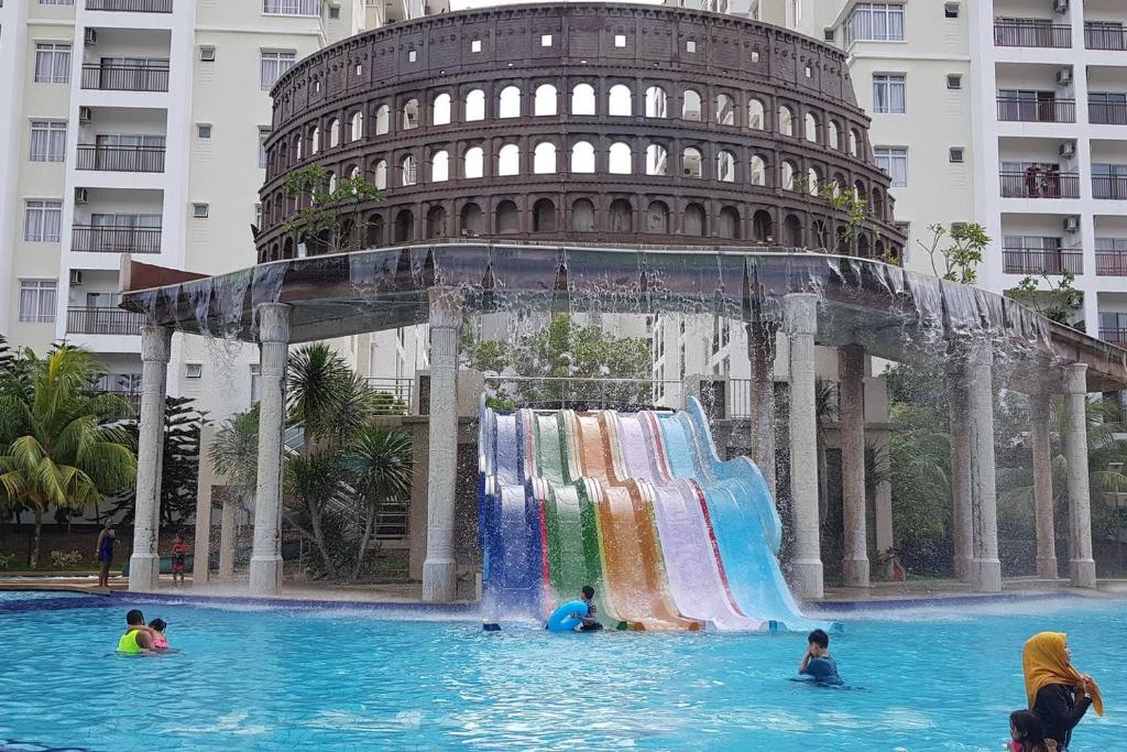 un gruppo di persone nell'acqua di fronte alla torre pendente di 3 Bedrooms at Lagoon Park Resort a Malacca