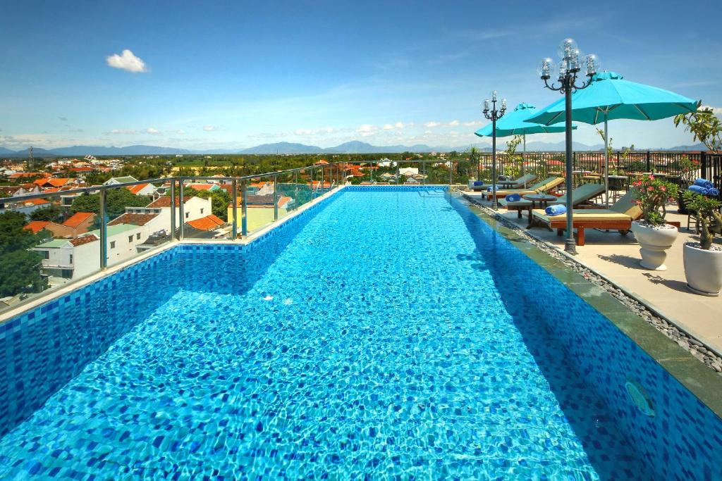 a large swimming pool on the roof of a building at Uptown Hoi An Hotel & Spa in Hoi An