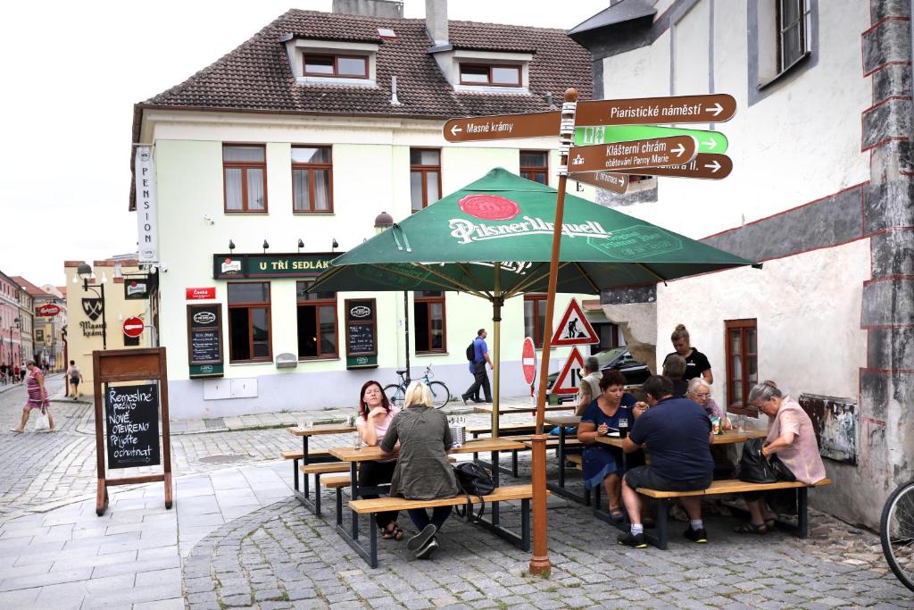 a group of people sitting at a table under an umbrella at Pension U Tří sedláků in České Budějovice