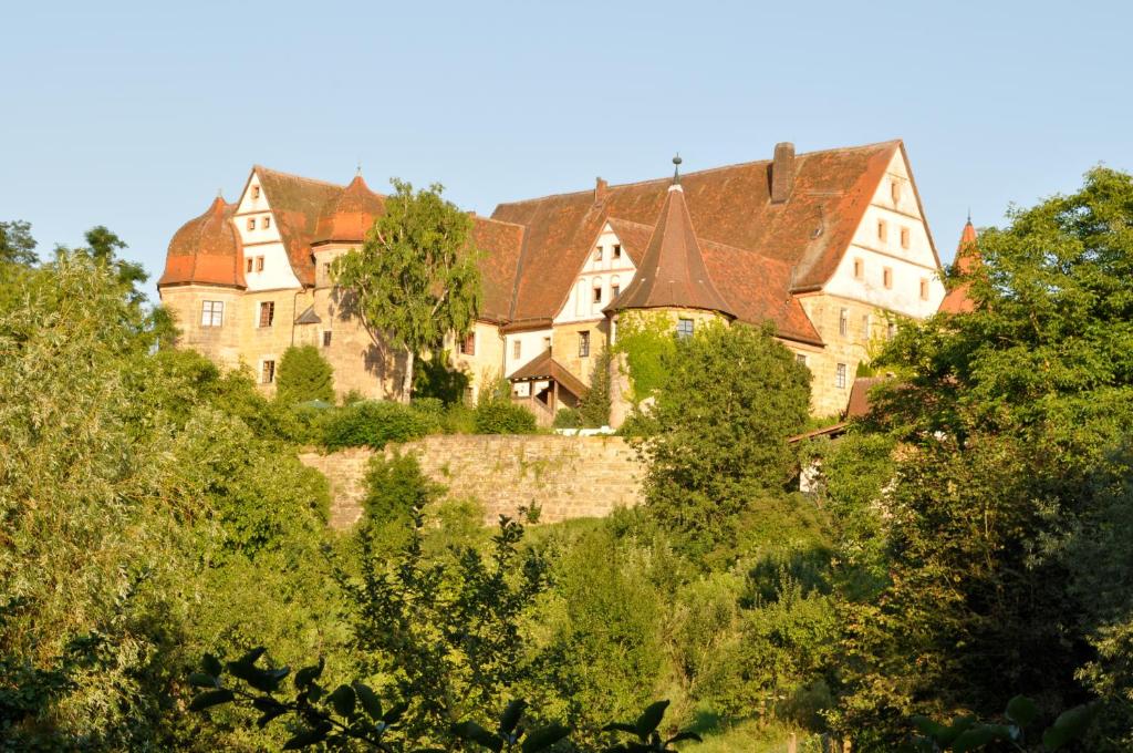 un château au sommet d'une colline plantée d'arbres dans l'établissement Schloss Wiesenthau, à Forchheim