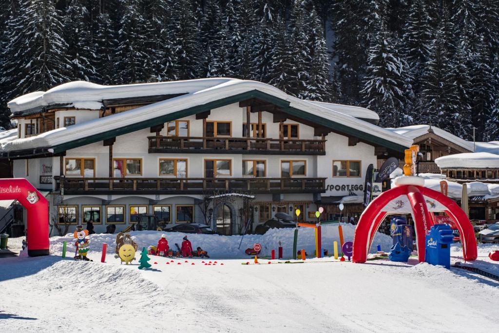 ein schneebedecktes Gebäude mit einem Spielplatz davor in der Unterkunft Hotel Mitterhof in Gerlos