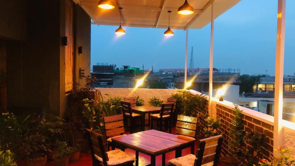 un patio con tavoli e sedie su un balcone di Tuk Tuk Backpackers Jaipur a Jaipur