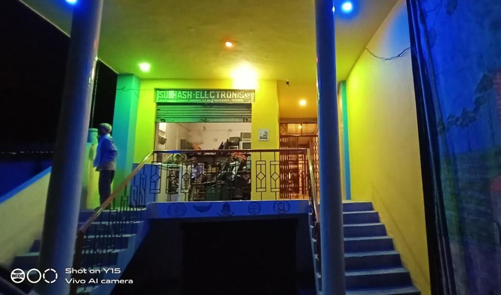 Un escalier mène à un bâtiment aux murs verts et jaunes. dans l'établissement MAYUR paying Guest house, à Varanasi