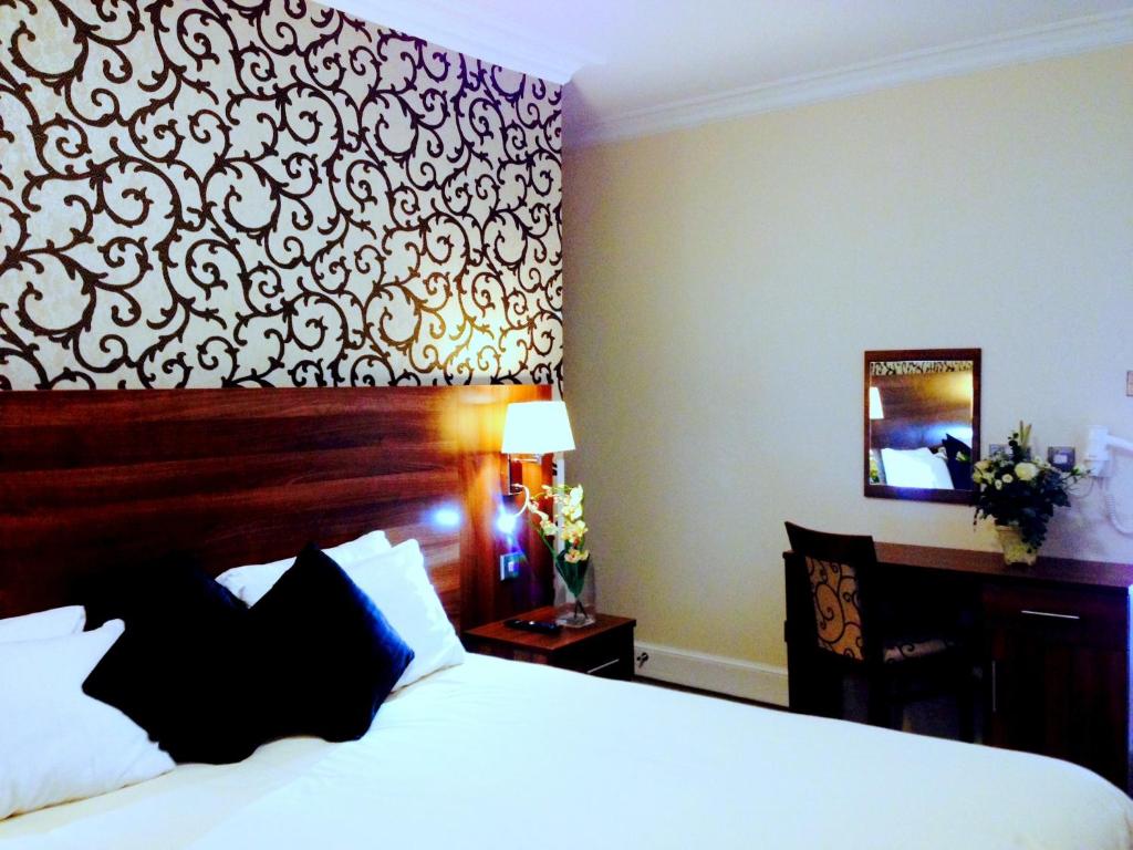 um quarto de hotel com uma cama e uma secretária em Ely House Hotel em Wolverhampton