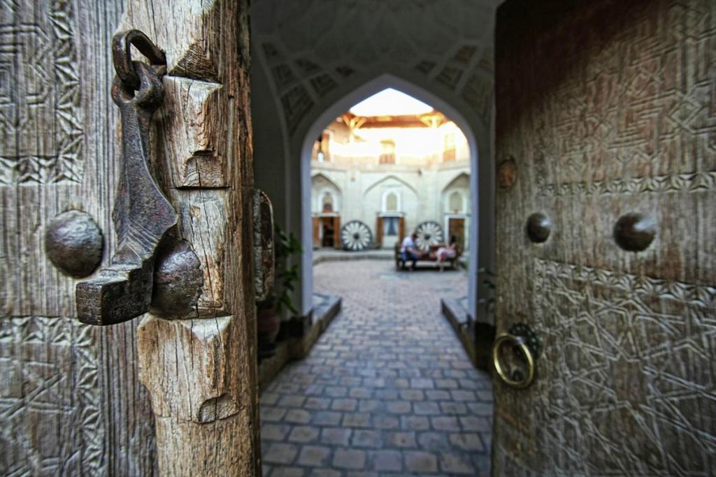 drewniane drzwi z uchwytem w korytarzu w obiekcie Amulet Hotel w mieście Buchara