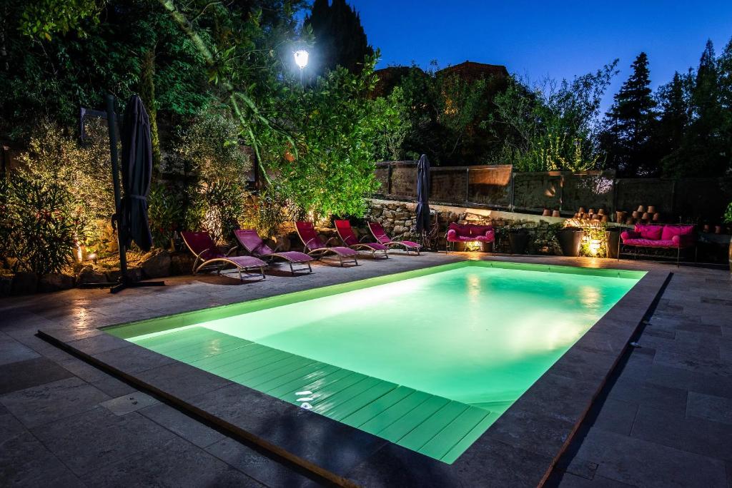 a swimming pool in a backyard at night at Chambre et Gite Le Roc sur l'Orbieu in Carcassone