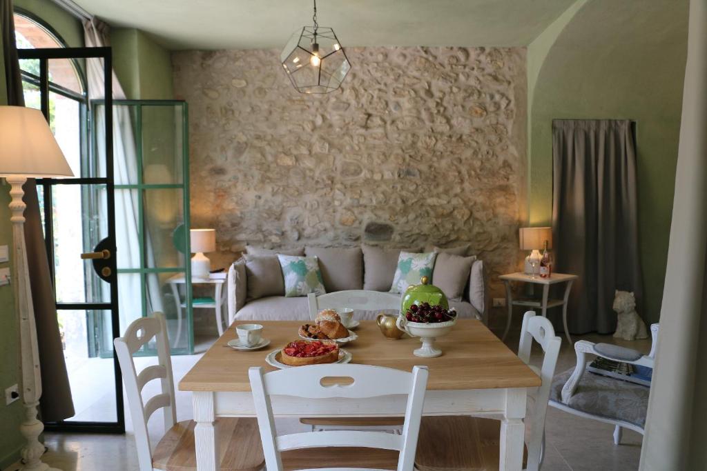 een woonkamer met een tafel en een bank bij Rambaldi Apartments Casa nr 4 Garden in Bardolino