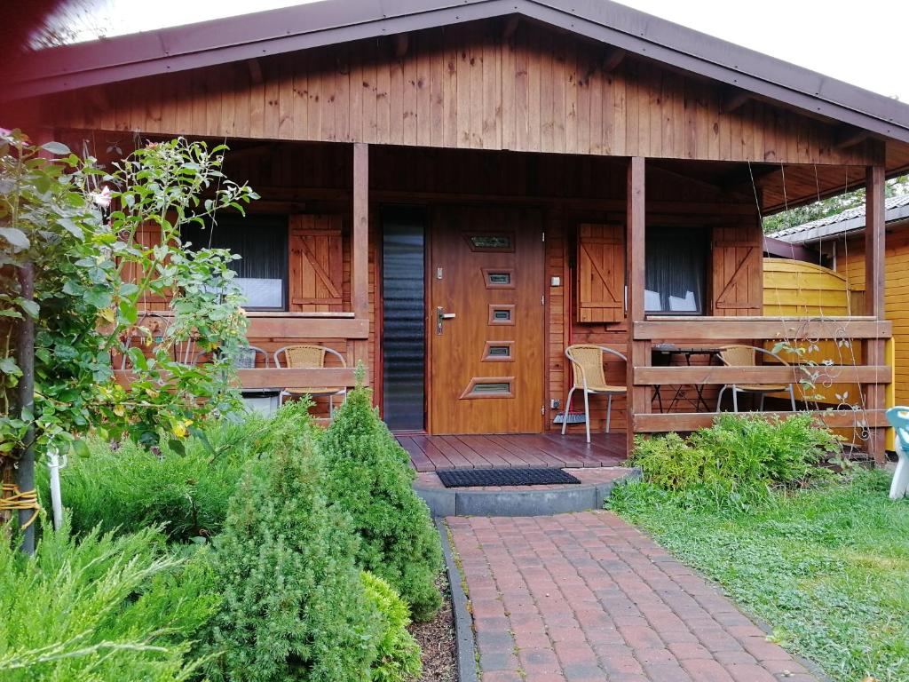 a house with a wooden door and a patio at Domek Letniskowy w centrum Mikołajek in Mikołajki