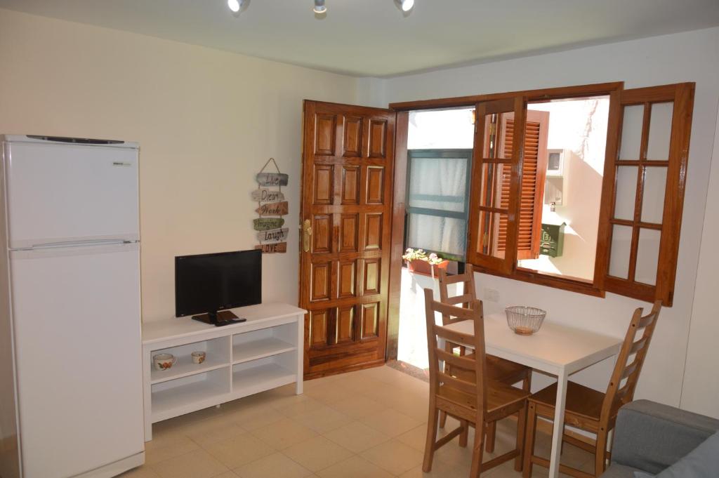 a living room with a table and a tv and a kitchen at La Niña in San Sebastián de la Gomera