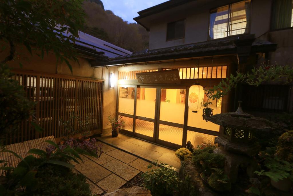 een toegang tot een huis 's nachts met een poort bij Yoshinoonsen Motoyu in Yoshino