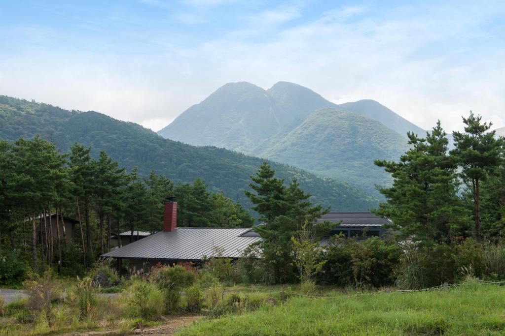 uma casa em frente a uma serra em Oita Kuoritei em Kokonoe