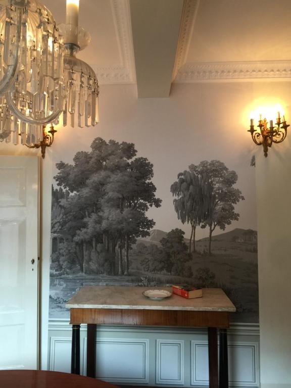 een schilderij van bomen op een muur met een tafel bij Castiglione 27 Luxury Suite in Bologna