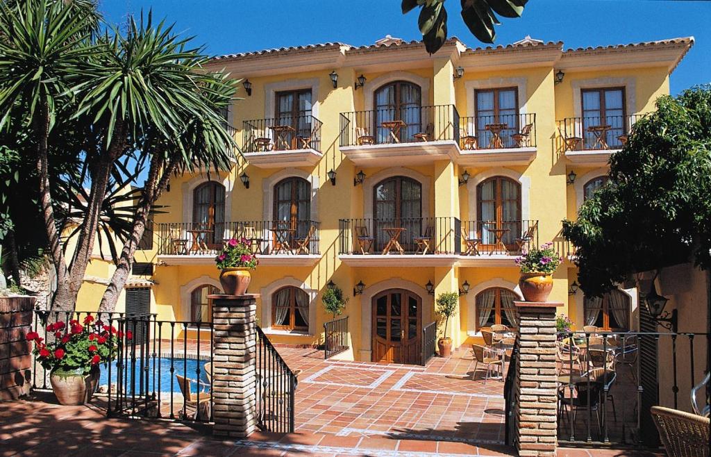 une maison jaune avec une piscine en face de celle-ci dans l'établissement Hotel Restaurante La Masieta, à Creixell