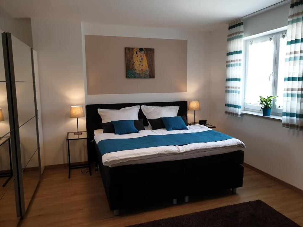 um quarto com uma cama grande e almofadas azuis em Steinackerhof em Burgthann