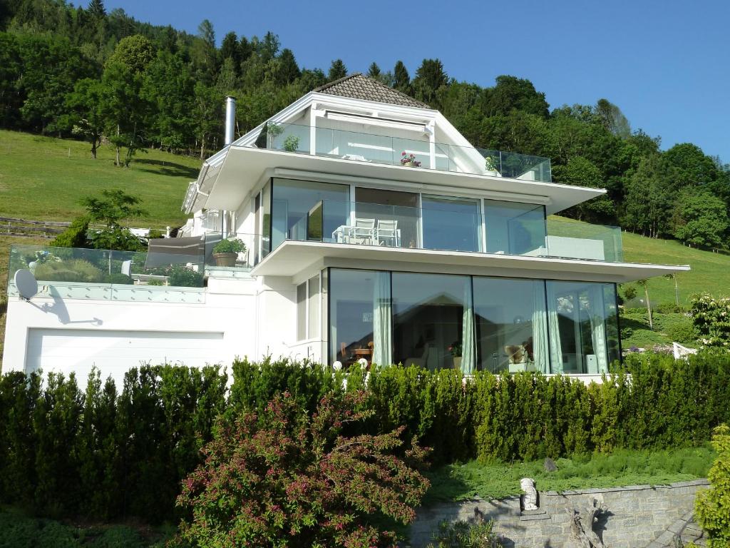 ein großes weißes Haus mit großen Glasfenstern in der Unterkunft Weisse Villa in Millstatt