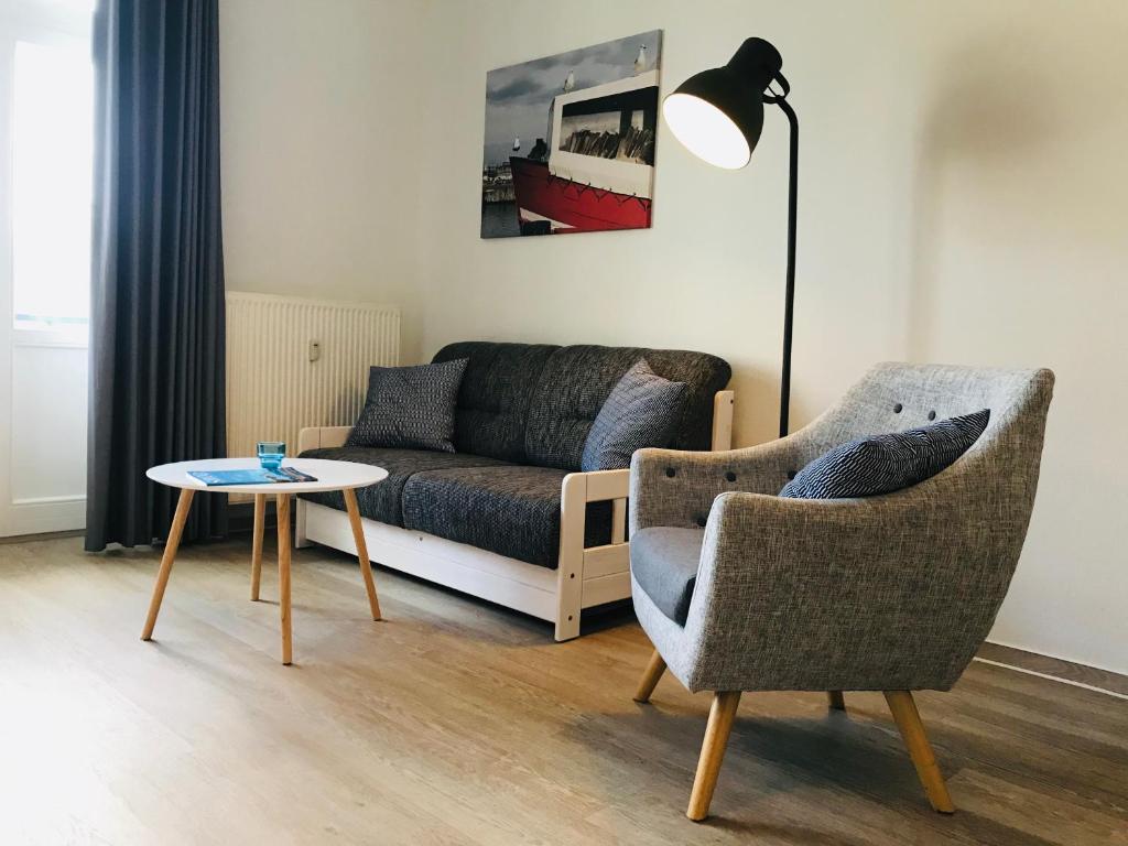 a living room with a couch and two chairs and a table at Haus am Park - Wohnung 24 in Kühlungsborn