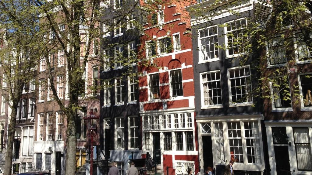 a red brick building with white windows on a street at Sonnenberg Canal View in Amsterdam