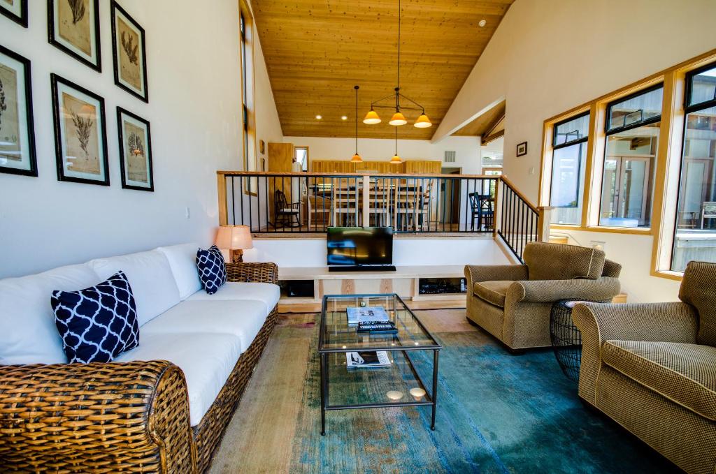 ein Wohnzimmer mit einem weißen Sofa und einem Glastisch in der Unterkunft Del Mar Meadow in Sea Ranch