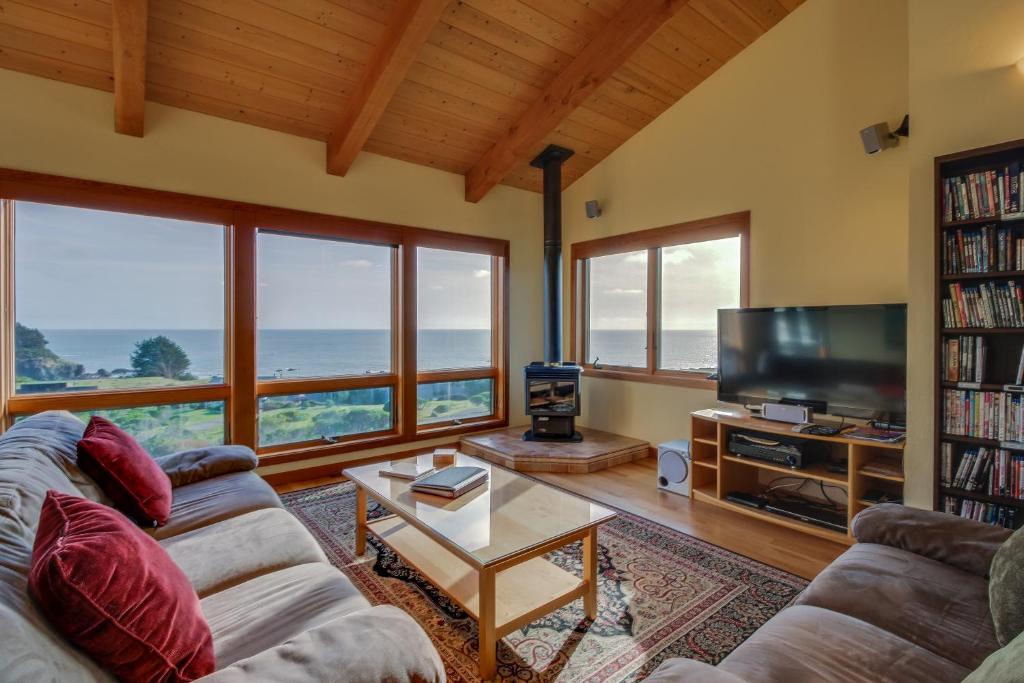 a living room with a couch and a tv at Ascona House in Sea Ranch