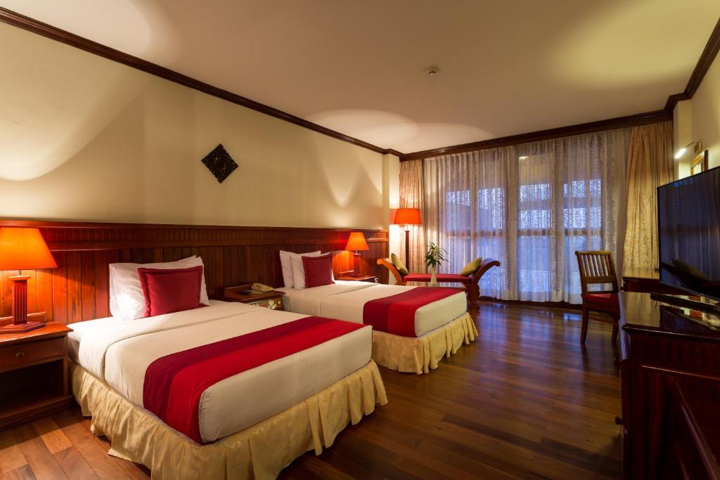 Postel nebo postele na pokoji v ubytování Angkor Paradise Hotel