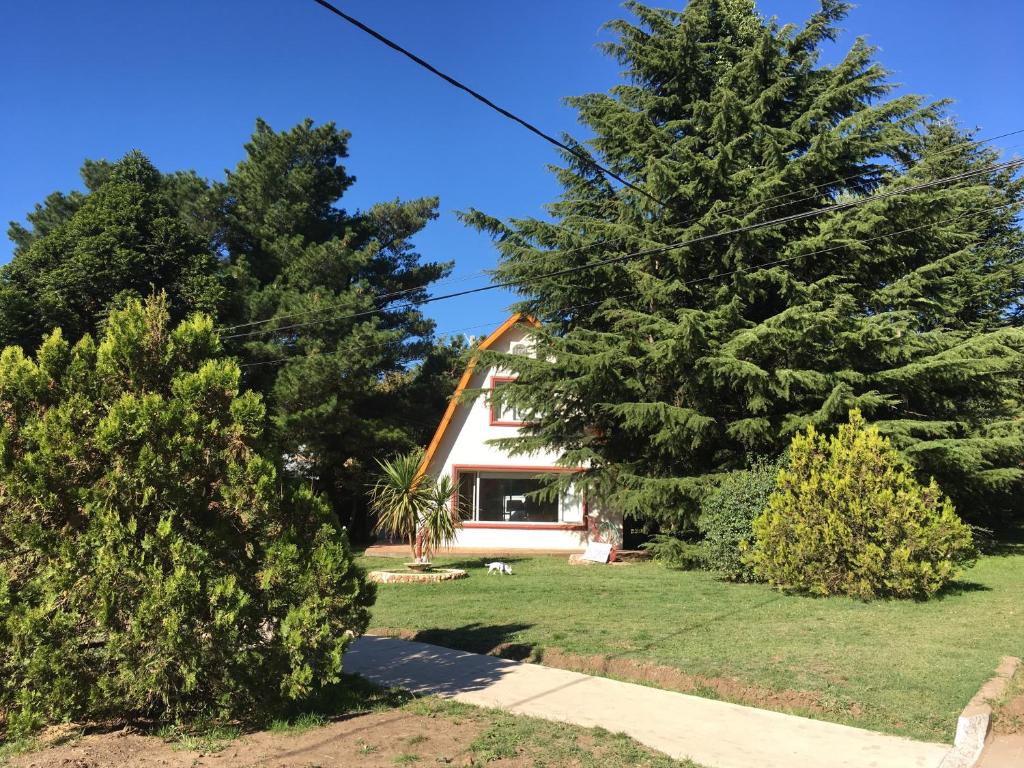 una casa con dos árboles delante de ella en Misky Samay (Dulce Descanso) en Villa Ventana