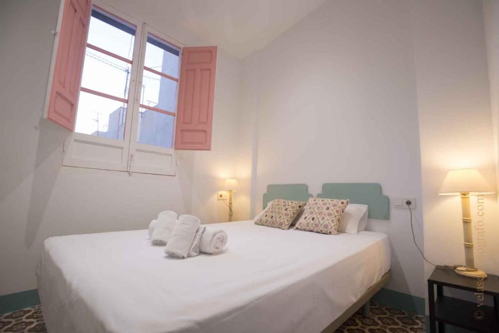 sypialnia z białym łóżkiem i ręcznikami w obiekcie Ático Auditorium w Alicante