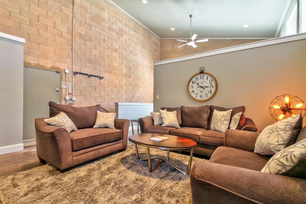 una sala de estar con 2 sofás y un reloj en la pared en Bella Casa - Loft, en Moab