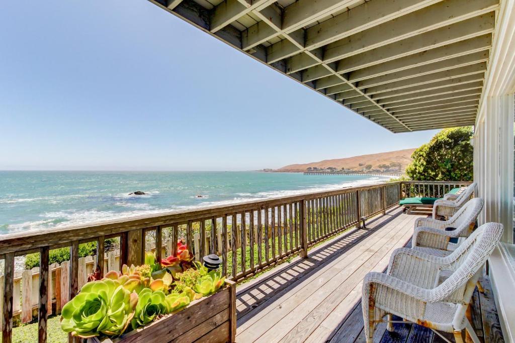 a balcony with chairs and a view of the ocean at Oceanfront Delight in Cayucos