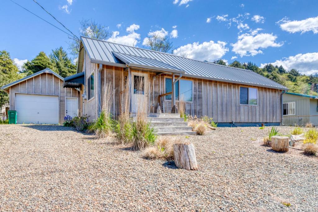 a house with a gravel yard in front of it at Calm Waters in Rockaway Beach