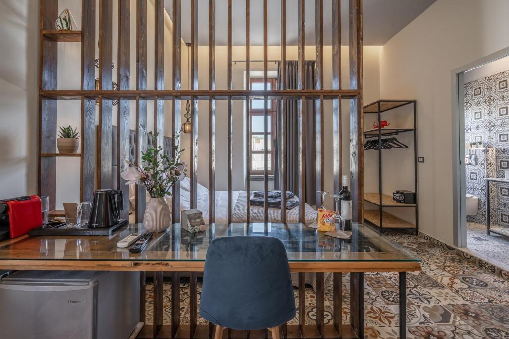ein Büro mit einem Glasschreibtisch und einem blauen Stuhl in der Unterkunft Casa Poli Suites in Rhodos (Stadt)