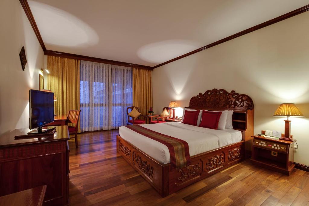 Postel nebo postele na pokoji v ubytování Angkor Paradise Hotel