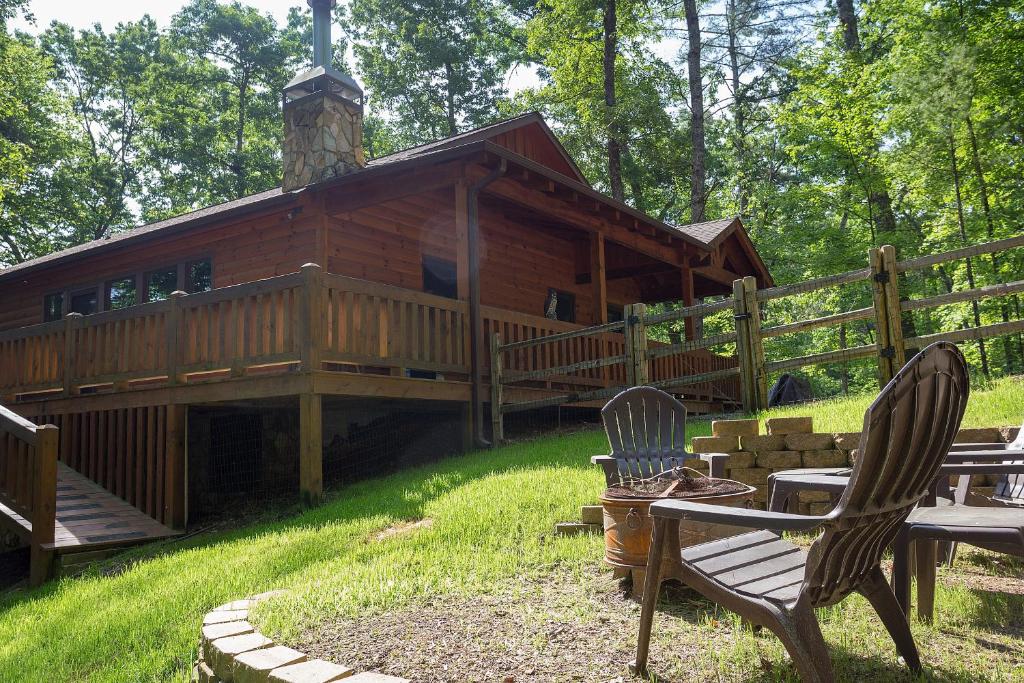 a log cabin with two chairs in front of it at Aska Woodlands in Aska