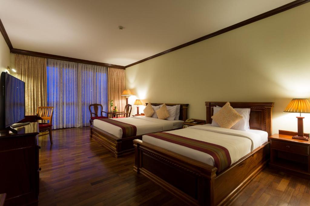 Postel nebo postele na pokoji v ubytování Angkor Paradise Hotel