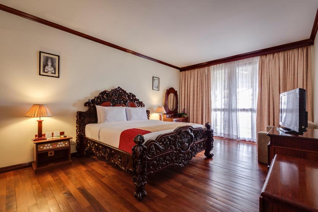 Postel nebo postele na pokoji v ubytování Angkor Paradise Hotel