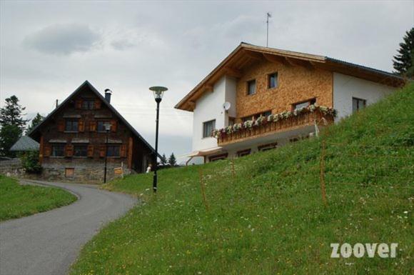 une maison sur une colline à côté d'une route dans l'établissement Haus Mondspitze, à Bürserberg