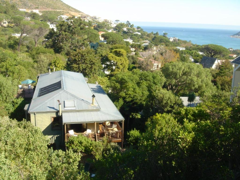 a house on a hill with the ocean in the background at Hout Bay Hideaway in Hout Bay