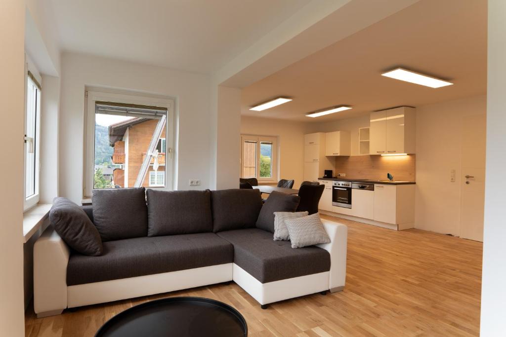 ein Wohnzimmer mit einem Sofa und einer Küche in der Unterkunft Moderne Ferienwohnung mit Ausblick in Bad Goisern