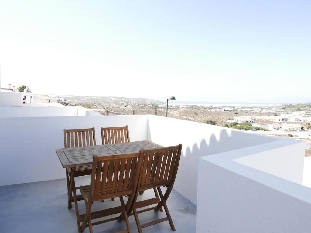 - Balcón con mesa de madera y 2 sillas en Casa na Carrapateira, Aljezur, en Carrapateira