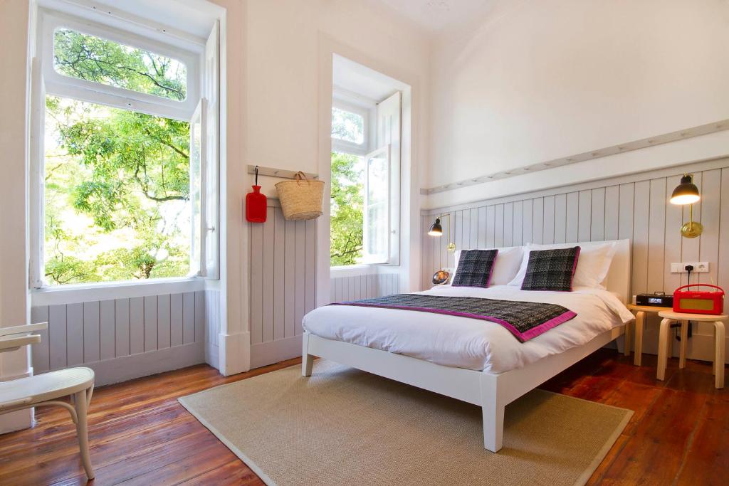 a bedroom with a white bed and two windows at Casa Oliver Boutique B&B - Principe Real in Lisbon